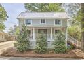 Charming two-story home with a metal roof, inviting front porch, and well-manicured landscaping at 918 Orient St, Durham, NC 27701
