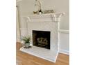 Close up view of the painted brick fireplace featuring decorative mantle and hearth at 1002 Springmill Ct, Apex, NC 27502