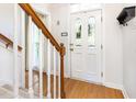 Foyer with hardwood floors, a decorative glass front door, a staircase with wooden handrail, and a white coat rack at 1002 Springmill Ct, Apex, NC 27502