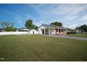 A well maintained lawn surrounds this beautiful home with a gravel driveway at 101 Pine St, Dunn, NC 28334