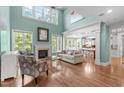 Bright living room with high ceilings, large windows, fireplace, and open layout to the kitchen at 103 Woodland Ridge Ct, Cary, NC 27519