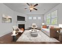 Cozy living room with fireplace, ceiling fan, and an abundance of natural light at 1047 Aberlour Ln, Burlington, NC 27215