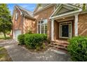 Welcoming front entrance with brick steps, lush landscaping, and a black front door at 107 Weslyn Trace Dr, Durham, NC 27703