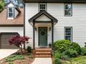 Inviting front entrance with a decorative door, brick steps, and mature landscaping at 107 Whitby Ct, Cary, NC 27511