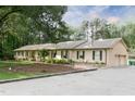 Spacious home with a beautiful brick facade, manicured landscaping, and an expansive driveway leading to an attached garage at 11 Pine Forest Dr, Siler City, NC 27344