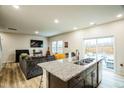 Open-concept space featuring a large living room, kitchen island, and sliding glass doors to the backyard at 1108 Orchard Stream Dr, Haw River, NC 27258