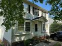 Two-story home featuring a covered front porch, brick steps, and landscaped garden beds at 1211 Odyssey Dr, Durham, NC 27713