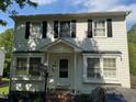 Charming two-story home with a classic white facade, black shutters, and covered front entry at 1211 Odyssey Dr, Durham, NC 27713