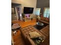 Open living room with modern furniture, hardwood floors, and large screen television at 1211 Odyssey Dr, Durham, NC 27713