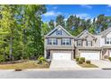 Attractive two-story townhome with two-car garage, stone accents, and charming front garden at 1230 Wingstem Pl, Raleigh, NC 27607
