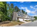 A row of attractive townhomes, with manicured lawns, set along a quiet street with mature trees at 1230 Wingstem Pl, Raleigh, NC 27607