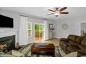 Bright living room featuring fireplace, ceiling fan, and access to the back deck at 1305 Montreux Ct, Mebane, NC 27302