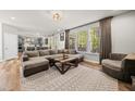 Open-concept living room featuring a plush sectional sofa, large windows, and modern decor at 140 Barletta Ct, Clayton, NC 27527