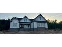 New home with gray siding, black roof accents, and stone foundation against a natural setting at 1403 Cottondale Lane, Wake Forest, NC 27587