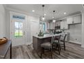 Bright, open kitchen with island, pendant lights, light gray cabinets, and outside access at 145 Leisure Ln # 12, Louisburg, NC 27549