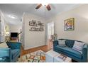 Inviting living room with stylish blue sofas, colorful rug, and decor with framed photos on shelves for a cozy atmosphere at 200 Wood Hollow Dr, Cary, NC 27513
