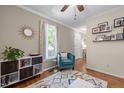 Cozy living room featuring hardwood floors, neutral wall paint, and a comfortable chair by the window with colorful curtains at 200 Wood Hollow Dr, Cary, NC 27513