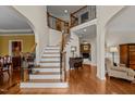 Elegant foyer with hardwood floors, staircase with wrought iron spindles and arched entryways at 2053 Monthaven Dr, Wake Forest, NC 27587
