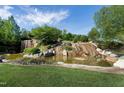 Scenic waterfall cascading over rocks into a pond, surrounded by lush greenery in the Legacy community at 213 North Crest Dr, Chapel Hill, NC 27517