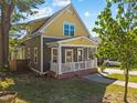 Exterior view showcasing the home's yellow and gray facade, complemented by a charming front porch at 215 Haywood St, Raleigh, NC 27601
