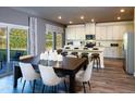 Open concept dining room featuring a modern table setting, sliding glass doors, and a seamless transition to the kitchen area at 2215 Cherry Creek Rd, Haw River, NC 27258