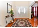 Elegant foyer with hardwood floors, double doors, a decorative rug, and stylish console table at 226 Marshview Cir, Angier, NC 27501