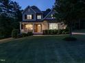 Charming two-story home with a stone-accented porch and manicured lawn illuminated at dusk at 2317 Emerald Woods Dr, Wake Forest, NC 27587