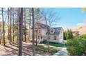 Stunning two-story home with a light exterior, attached garage, and surrounded by beautiful mature trees at 2418 Mont Haven Dr, Durham, NC 27712