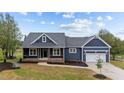 Charming home featuring a covered porch and an attached two-car garage, with landscaped yard at 25 Leisure Ln # 2, Louisburg, NC 27549