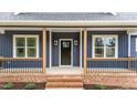 Inviting front porch with brick accents, stylish railings, and a contemporary front door with sidelights at 25 Leisure Ln # 2, Louisburg, NC 27549