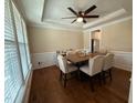 Traditional dining room featuring hardwood floors, a ceiling fan, and beige walls with bright trim at 2709 Sardinia Ln, Apex, NC 27502