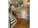 Bright foyer with hardwood floors, staircase, and an upper level landing with decorative wrought iron railing at 2709 Sardinia Ln, Apex, NC 27502