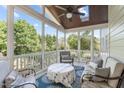 Inviting screened porch with comfortable seating, ceiling fan, and a view of the trees at 2832 Cameron Pond Dr, Cary, NC 27519