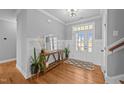 Welcoming foyer featuring a wooden console table, stylish mirror, plants, and a decorative rug at 30 Devilwood Dr, Four Oaks, NC 27524