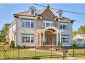 Beautiful two-story home with brick and siding, featuring dormer windows and a fenced front yard on a sunny day at 301 Georgetown Rd, Raleigh, NC 27608