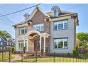 Attractive two-story home with brick and siding, showcasing dormer windows and a fenced front yard at 301 Georgetown Rd, Raleigh, NC 27608