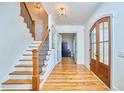 Bright foyer featuring hardwood floors, elegant lighting, and a staircase with wooden treads and iron railing at 301 Georgetown Rd, Raleigh, NC 27608