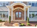 Inviting front porch with a brick archway, elegant double doors, and decorative shrubs, creating a welcoming entrance at 301 Georgetown Rd, Raleigh, NC 27608