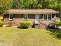 Quaint brick home with inviting front lawn, mature trees, and charming exterior shutters at 3016 Fields Dr, Raleigh, NC 27603