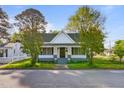 Charming white house featuring a welcoming front porch framed by mature trees and curb appeal at 302 N Sumner St, Selma, NC 27576