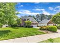 Charming brick and vinyl home and landscaped front yard with driveway at 308 Ravenstone Dr, Cary, NC 27518
