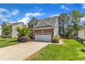 Two-story brick home boasts an attached two car garage and driveway at 308 Ravenstone Dr, Cary, NC 27518