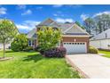 Beautifully landscaped front yard with brick and vinyl home and attached garage at 308 Ravenstone Dr, Cary, NC 27518