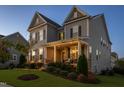Stylish two-story home at dusk with a covered porch and professional landscaping at 3209 Star Gazing Ct, Wake Forest, NC 27587