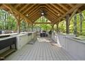 Outdoor kitchen with a built-in grill, countertops, and wooden beams creating a perfect space for entertaining at 359 Heather Bluffs Dr, Garner, NC 27529