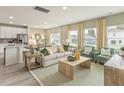 Bright open-concept living area with stylish furniture, hardwood floors, and large windows at 3853 Rosebush Dr, Zebulon, NC 27597