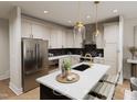 A well-lit, modern kitchen featuring stainless steel appliances, marble countertops, and pendant lighting over the island at 3926 Lost Fawn Ct, Raleigh, NC 27612