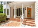 Inviting front porch with brick flooring and white columns, leading to an attractive front door at 4012 Graham Newton Rd, Raleigh, NC 27606
