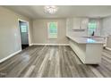 Eat-in kitchen featuring white cabinets, gray-toned floors, and a view to the outside at 42 S 2Nd St, Roxboro, NC 27573