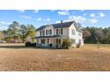 Attractive two-story home with a covered porch, set on a spacious lot under a blue sky at 4208 Louisbury Rd, Wake Forest, NC 27587